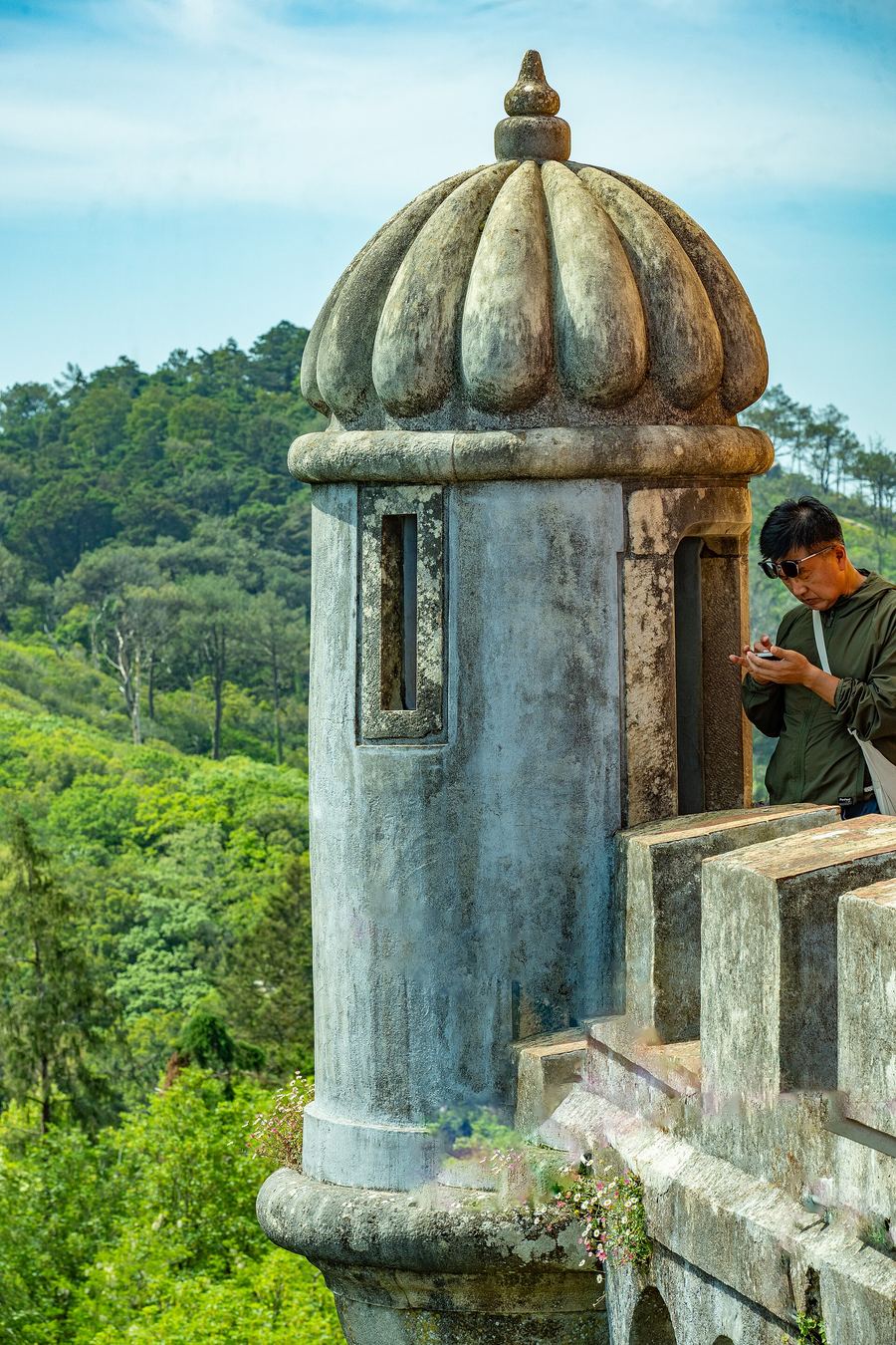 A traveler checking a smartphone on a hilltop path